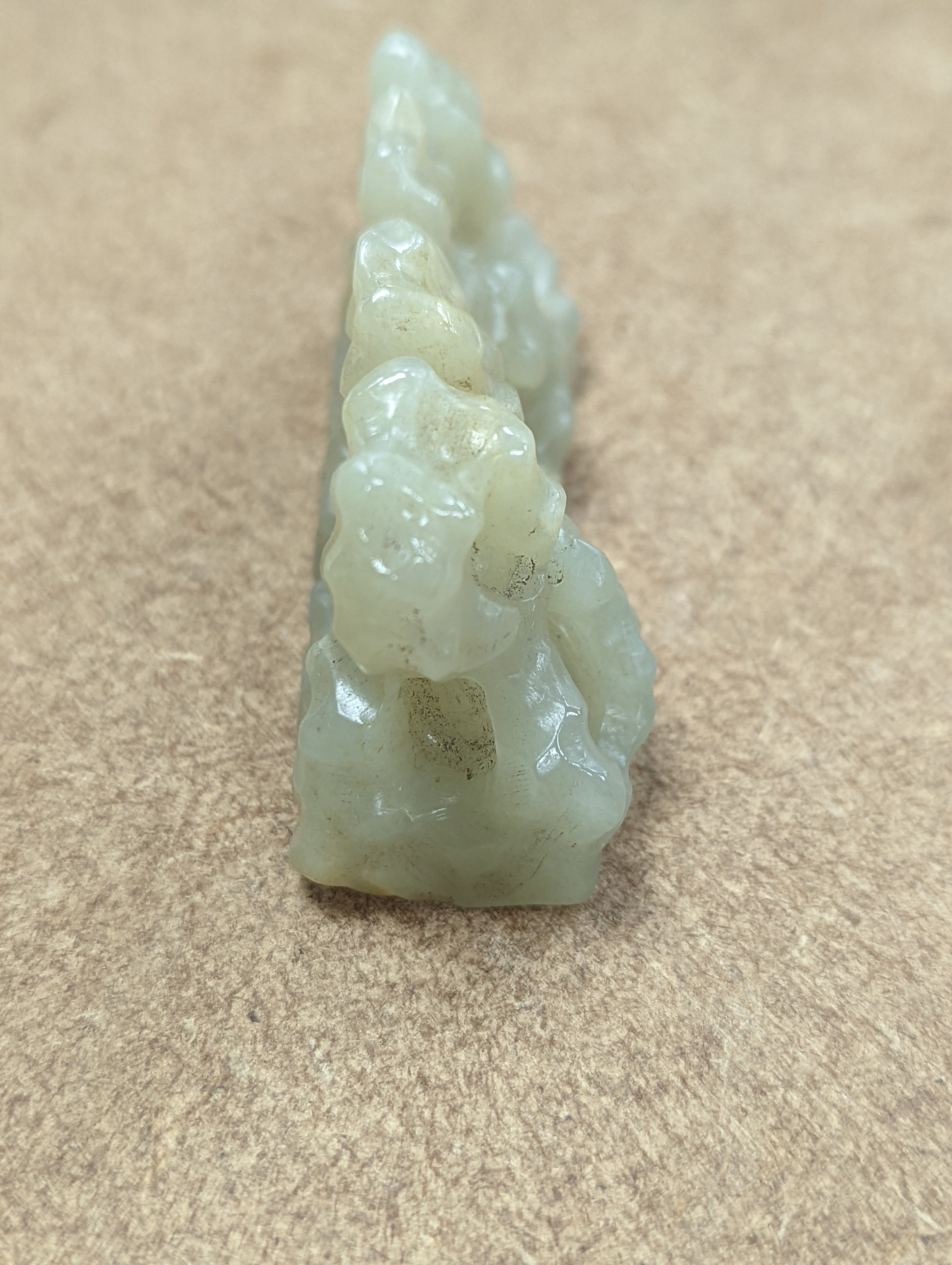 A Chinese celadon jade brush rest, 8cms wide